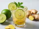 Imagem destacada de um copo refrescante de suco de limão com gengibre, com limões frescos, gengibre e hortelã em um fundo minimalista, simbolizando saúde e emagrecimento.